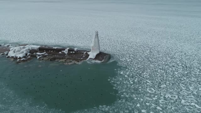 Frozen Waves of Lake Michigan Hit Elevated Catwalk of Light House Amidst Water