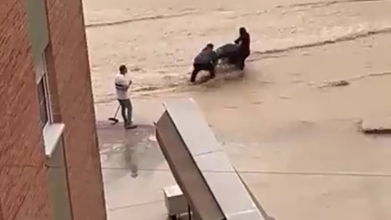 Mother tries to cross floodwaters with her child in a stroller