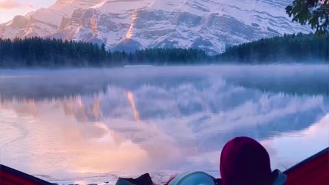 "Winter Wonder: A Peaceful Scene of a Loved One on a Swing Overlooking a Frozen Lake."