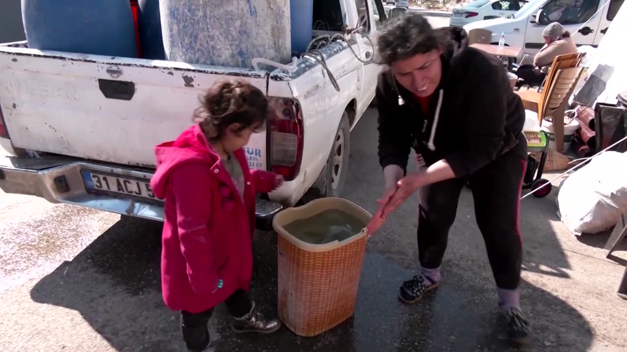 A family camps out on street outside quake-hit home