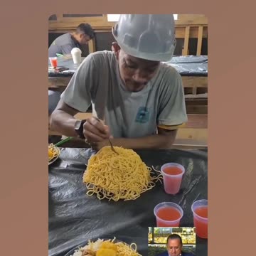 Construction worker who looks like Snoopy Dog devours a mountain of pasta