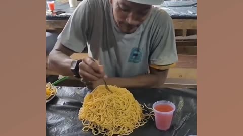 Construction worker who looks like Snoopy Dog devours a mountain of pasta