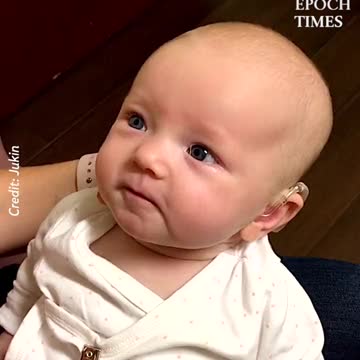 She was born deaf but had hearing device put in. First time she's heard her mom's voice