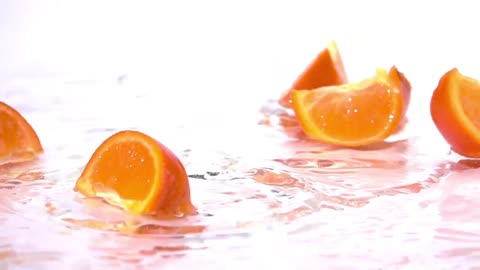 Orange slices falling into water