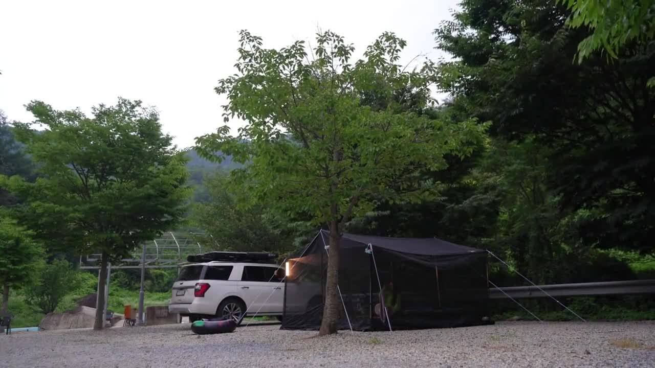 Outdoor camping, tent under the tree when the weather is too hot to enjoy cool food