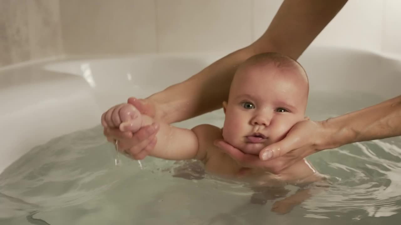 Person puts a baby in the bathtub