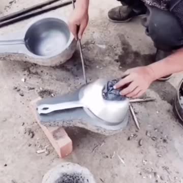 Chinese skilled worker melting metal to make frying pan