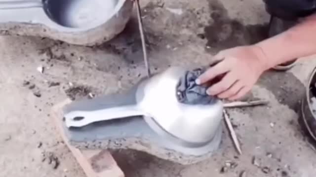 Chinese skilled worker melting metal to make frying pan