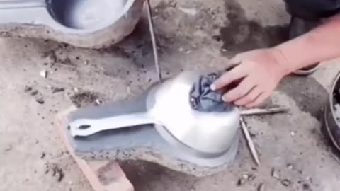 Chinese skilled worker melting metal to make frying pan