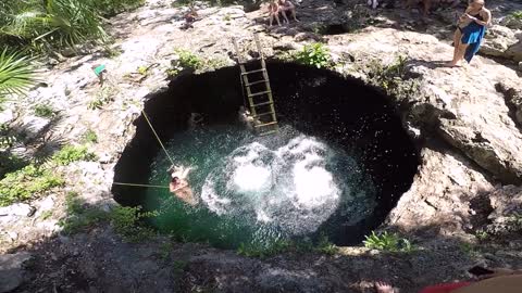 Two Women Jumping Down A Water Hole