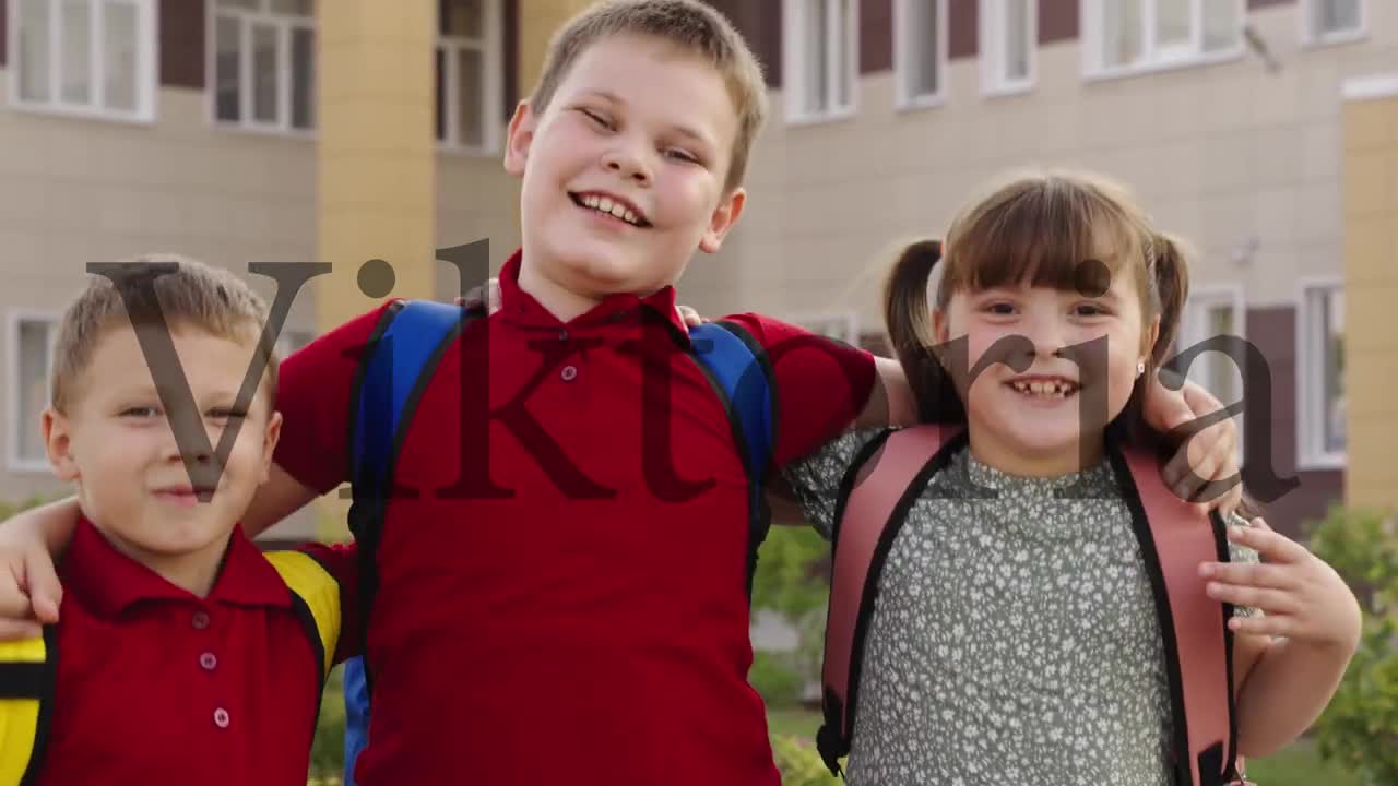 child schoolchildren hugging smiling school yard. Portrait happy students with backpacks outside