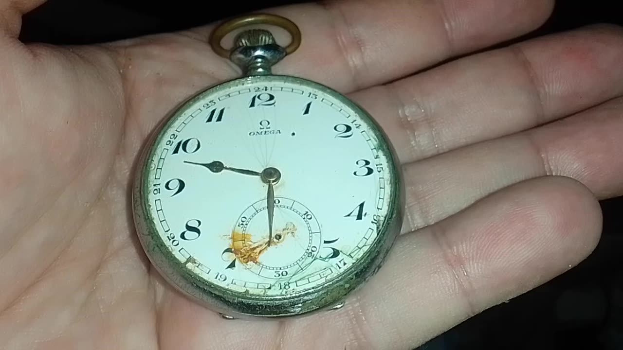 Guy holding an antique 1912 Swiss Omega Pocket Watch Silver broken in his hand, over 100 years old