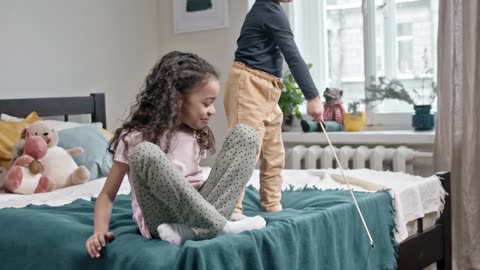 Kids Playing Catch The Bait With Their Cat In The Bedroom