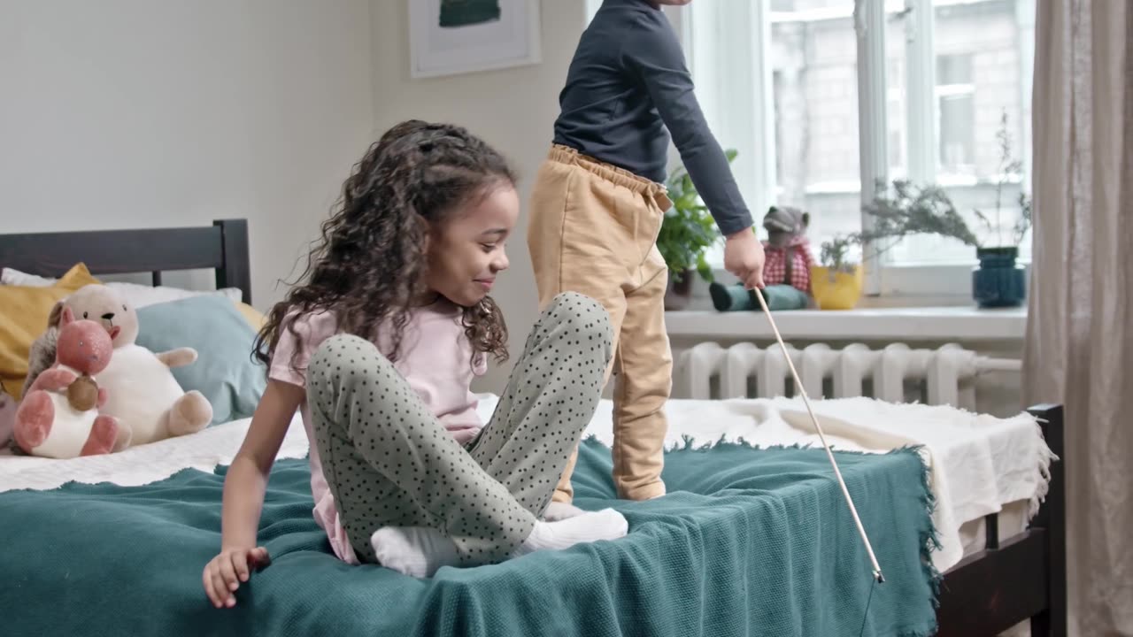 Kids Playing Catch The Bait With Their Cat In The Bedroom