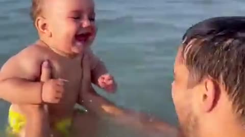 baby laughing at the beach