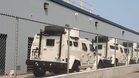 Several UN Armoured trucks aligned behind a pharmaceutical building, Ontario, Canada July 18th 2021