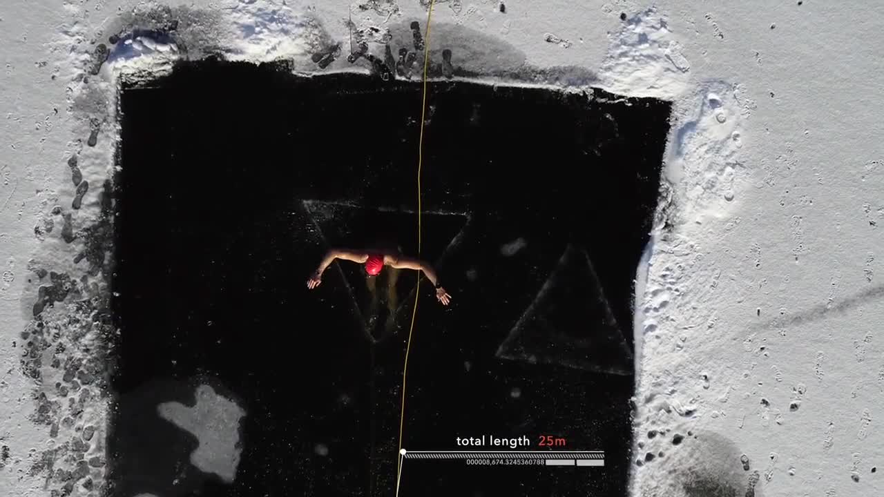 Man Performs Under Ice Diving and Swims in Freezing Temperature