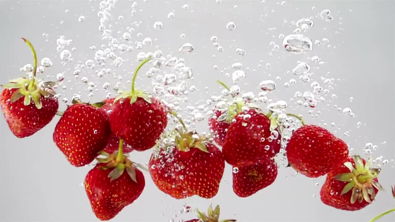 A bunch of strawberries falling through water