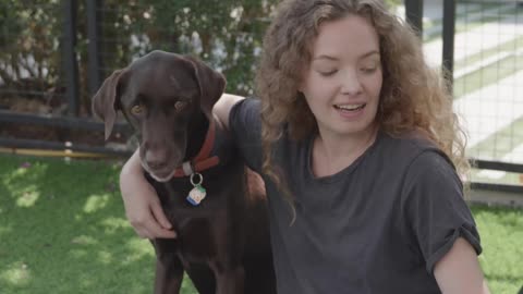 A Woman Petting Her Dogs Outdoors