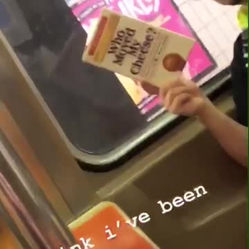 Man reads who moved my cheese on subway