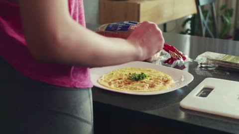 Young woman finishing preparing her breakfast