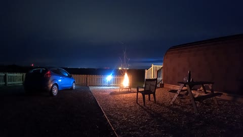 Campfire next to a glamping pod. Nightlapse