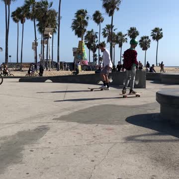 Kid in white shirt near beach skateboard