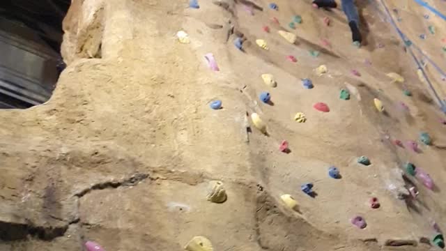 Father vs daughter climbing wall race.