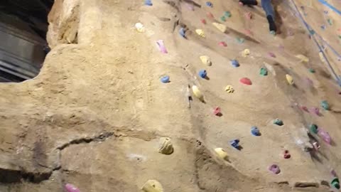 Father vs daughter climbing wall race.