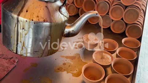 In several Kulhad, a cook pours hot tea to sell on the streets of Kolkata, India