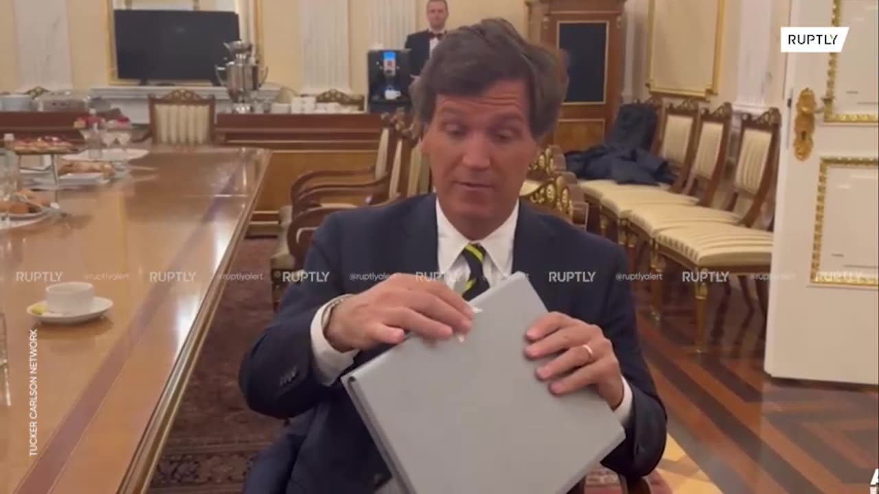 Tucker Carlson mostra il fascicolo o folder datogli da Putin