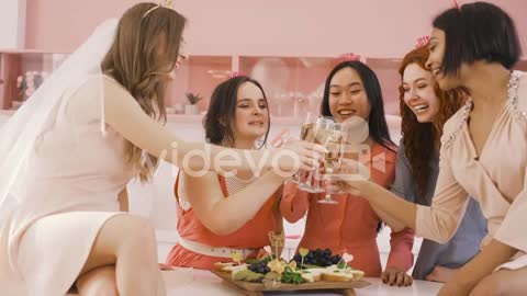Group Of Friends And Bachelor Girl Around A Table With Food Toasting With Champagne Crystal Glasses