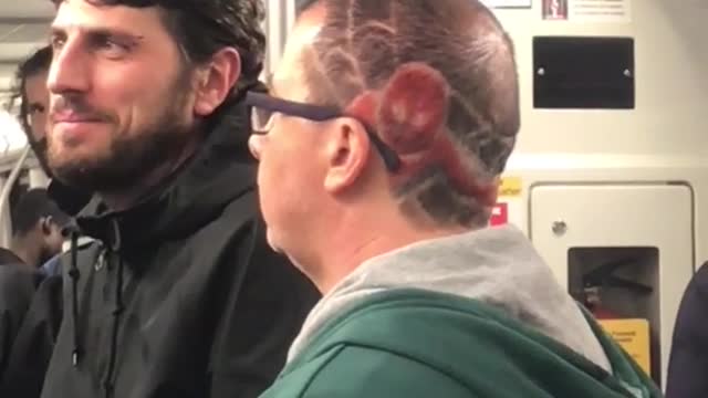 Man has red spiderman figure on hair head