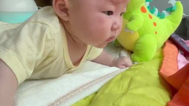 A baby girl is trying to hold her neck.