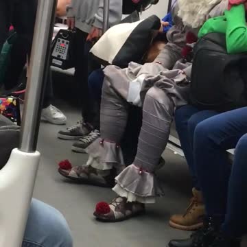 Man in clown it outfit sitting on the train