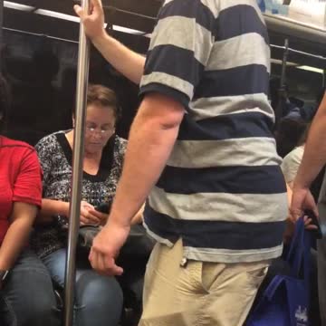Guy grey and blue striped shirt polo falling asleep standing up holding onto pole subway train
