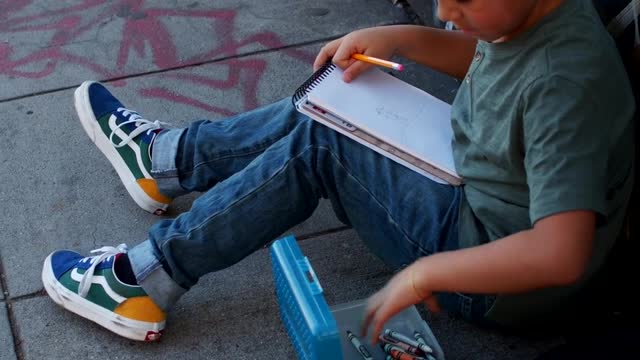 Boy Sitting While Coloring His Art Work