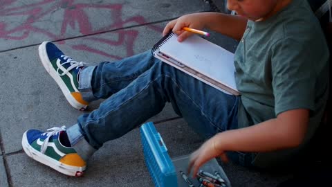 Boy Sitting While Coloring His Art Work