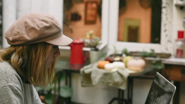 Young Woman Using Laptop while Having Breakfast