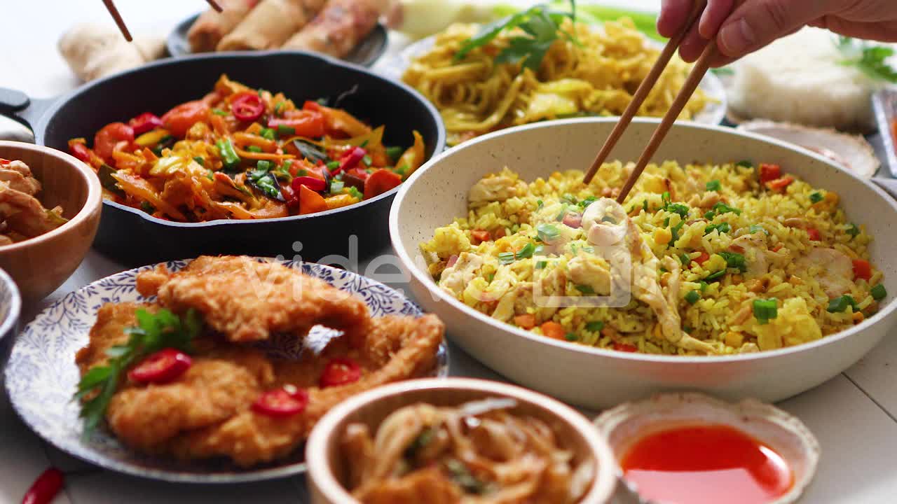 Family meal concept with asian food Plates pans and bowls full of tasty oriental dishes