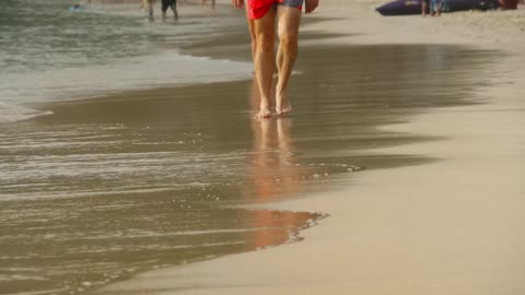 Barefoot man walking in the beach