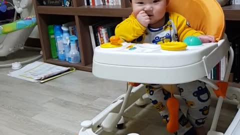 This is a video of a baby playing happily and smiling brightly.