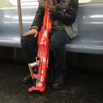 Man red toy gun reading book