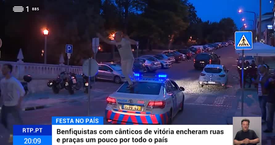 Adepto festeja vitoria do Benfica em cima de um carro da policia