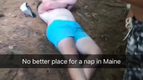 Drunk guy teal shorts asleep on dirt