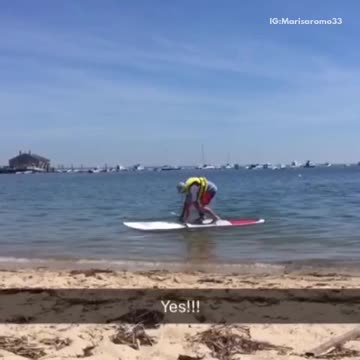 Guy yellow life vest paddleboard falls face first water