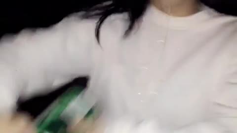 Girl in white shirt opening drink can with mouth