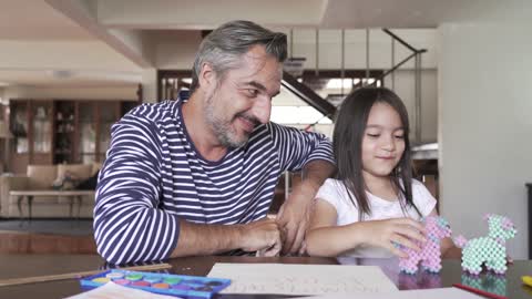 A Father Playing With Her Daughter With Toys