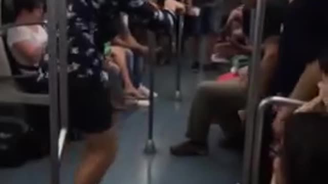 Guy blue button up shirt white shoes dancing on subway train