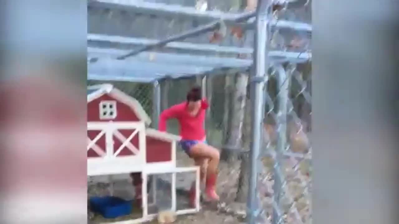 woman running from the rooster is trying to catch it for a spout